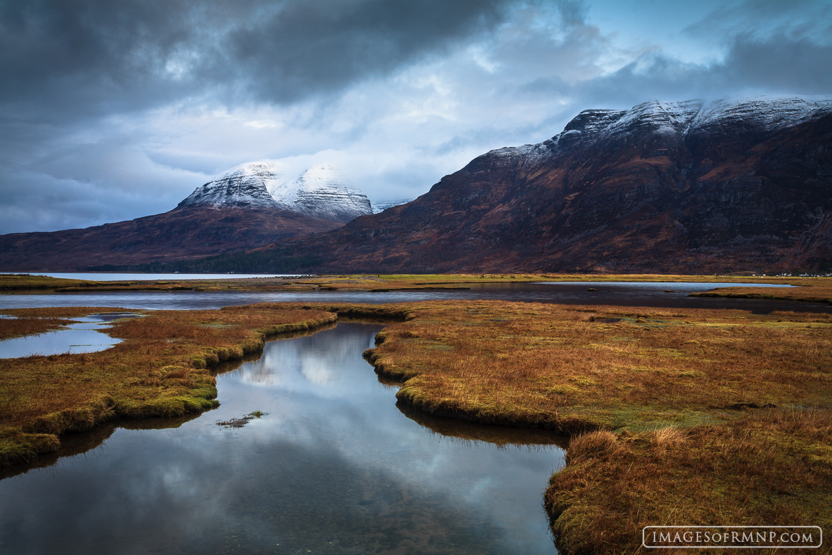 A fast moving storm over Upper Loch Torridon in the Scottish highlands with the imposing Beinn Allgin peak in the distance.